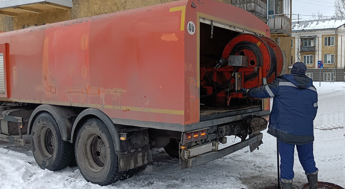 Каналопромывочная машина и работник прочищают засор в канализационной системе в Змеиногорске