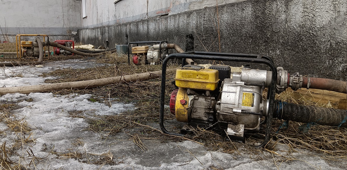 Откачка мотопомпами талой воды из подвала дома в Горняке